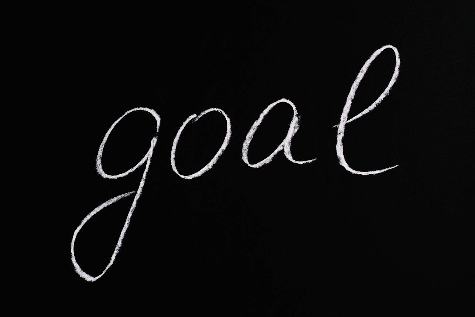 handwritten goal word in white against a black background